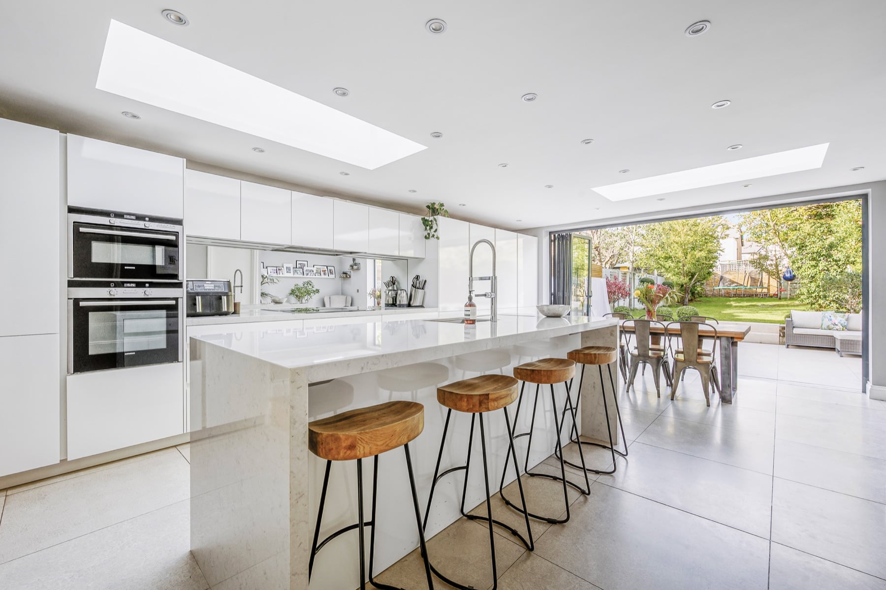 Bright kitchen with a breakfast bar opening onto the garden at Denmark Road